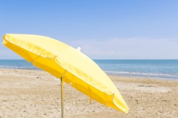 Umbrella on the beach, with the sea and sky in the background
