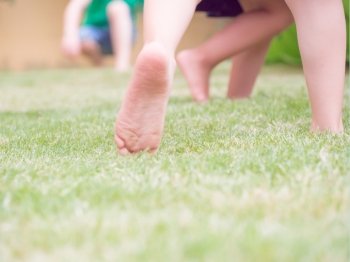 jump on the grass for happiness. Blur image  with feet of kid that jump on the grass. Concept of happiness