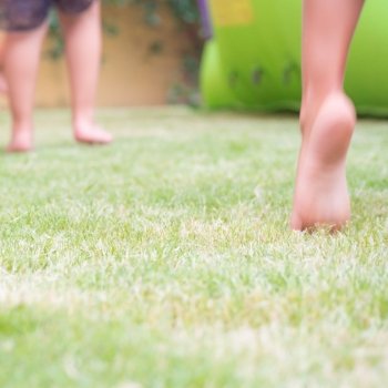 jump on the grass for happiness. Blur image  with feet of kid that jump on the grass. Concept of happiness