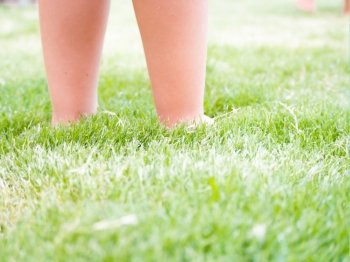 Feet Kid on the grass. feet of a child sinking in the grass. Concept of Freedom