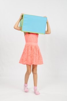 Six year old girl wearing a European-style box on his head, isolated on a light background