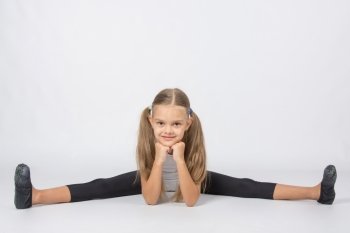 six year old girl aspiring gymnast performs a number of training exercises. Girl gymnast performs a cross twine