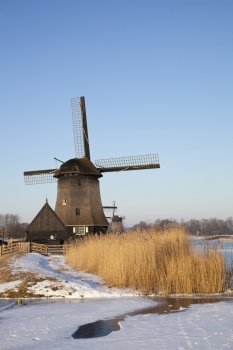 Windmill in winter time with snow, ice and blue sky