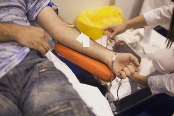 Blood donor’s arm up close while giving blood