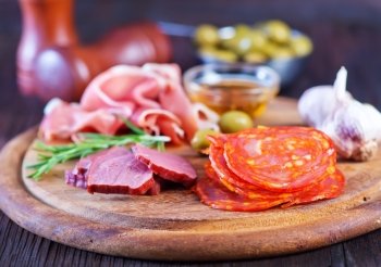 salami, sausages and ham on the wooden board