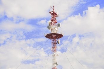 Transmitting antenna against a blue sky with white clouds