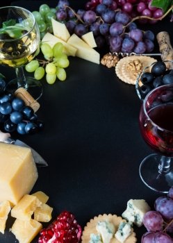 Wine and snacks arranged in the form of a border on a black background
