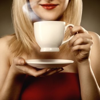 woman in red holding cup and smiles