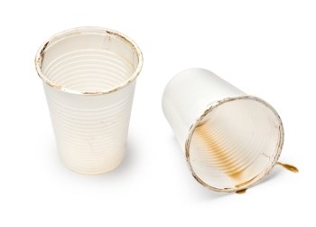 close up of empty used coffee cups on white background