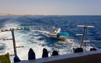 In the picture a moving ship , docked with a speedboat ,at forward  hooked  flippers and masks for snorkeling and in the background Egyptian coast .