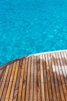 In the pictured curved wooden deck wet and in the background ocean blue / turquoise.