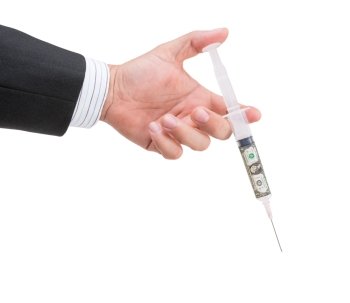 hand holding syringe filled with currency on white background