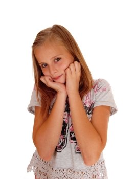 A lovely blond young girl standing for white background holding herhands on her chicks and smiling.
