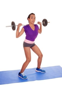 A slim and pretty African American woman lifting weight, standing isolatedfor white background with the weight behind her back.