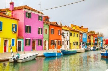 BURANO, ITALY - NOVEMBER 23: Brightly painted houses at the Burano canal on November 23, 2015 in Burano, Venice, Italy. It’s an island in the Venetian Lagoon, northern Italy.