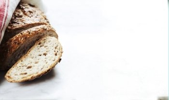 Freshly baked traditional bread on white marble background