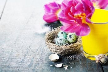 Easter composition with tulips, colorful eggs and nest