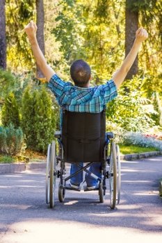young man in wheelchair with wide opened arms enjoying his life