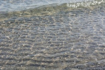 Clear transparent water background with ripples. Clear transparent shallow water background with ripples as seen on the beach