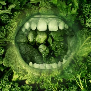 Eating green and healthy food concept with an open human mouth on a background of produce eating fresh vegetables as a symbol of good diet and nutrition and living a health lifestyle.