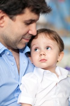 Happy young dad with a little son. Child looking at beloved father with his big blue eyes