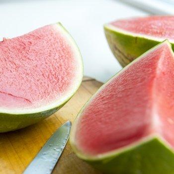 Fresh juicy watermelon sliced on wooden board in shallow focus