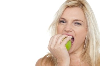Sexy blonde female eating fresh green apple. Sexy blonde female eating fresh green apple, closeup shot.