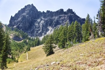 The rugged central portion of the Three Fingered Jack mountain in Central Oregon rises above an alpine mdedow.