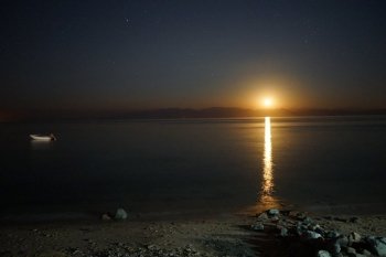 The Moon and motor boat at night in Dahab, Egypt
