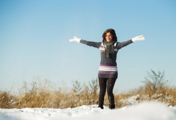 Happy young woman have fun and enjoy fresh snow at beautiful winter day 