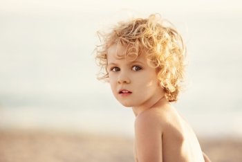 Adorable happy little girl on beach vacation, close up portrait