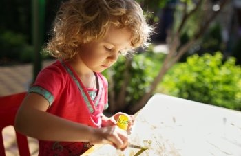Portrait of little girl painting, summer outdoor