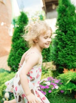 Little girl running on green grass