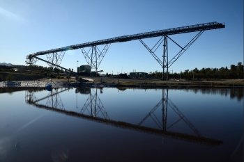 Steel infrastructure for loadout facilities reflected in a storage pond at a coal mine 