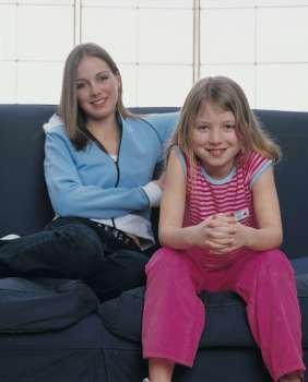 mother and daughter posing on a couch