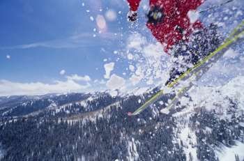 View of a skier throwing up snow while skiing on a mountain