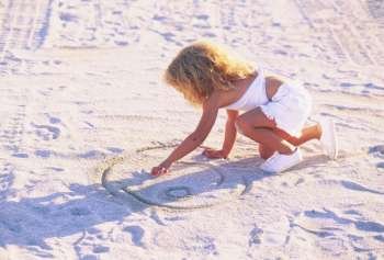 Girl drawing in the sand
