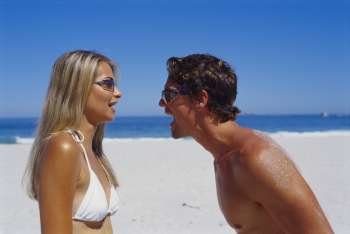 Young couple looking at each other on the beach