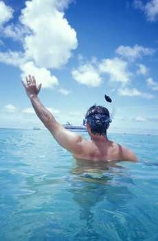 Man Snorkeling and Waving at Cruise Ship