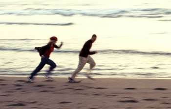 Couple Running Along Beach