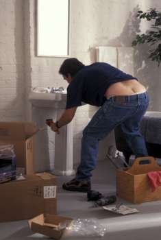 Plumber Bending Over To Fix Sink And Exposing Buttocks