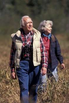 Elderly Couple Hiking Through Brush