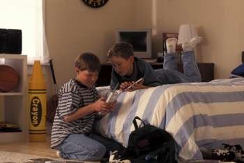 Boys Sitting In Bedroom Dialing Telephone