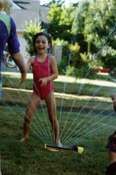 Girls Playing in Sprinkler