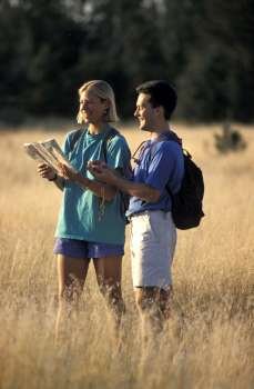 Man and Woman Hiking and Looking at Map