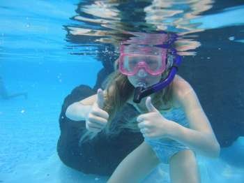 Underwater view of a young girl (12-13) swimming wearing scuba gear, Moorea, Tahiti, French Polynesia, South Pacific