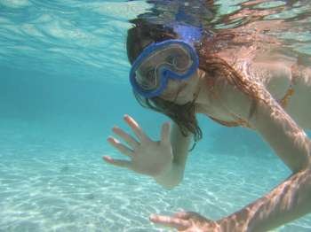 Underwater view of a young woman scuba diving, Moorea, Tahiti, French Polynesia, South Pacific