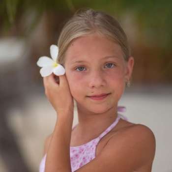 Young Girl Holding White Flower in Her Hair at Moorea in Tahiti