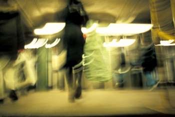 Women Walking With Shopping Bags In A Brightly Lit Subway