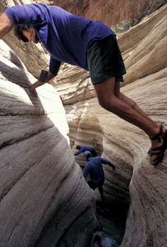 Hikers Scaling A Rock Crevice